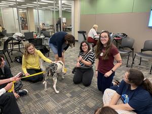 [Maren Garcia and Abigail Mueller with therapy dog]