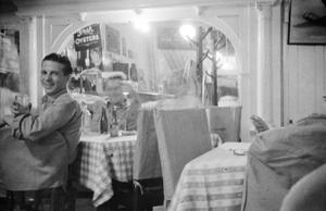 [Photograph of a man dining at a restaurant]