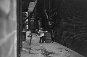 [Photograph of a child in an alley]