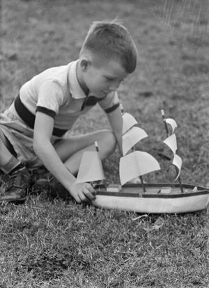 [Photograph of Tim Williams playing with a toy boat, 2]