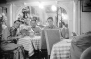 [Photograph of men sitting in a restaurant]