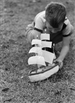 [Photograph of Tim Williams playing with a toy boat, 3]