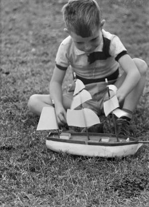[Photograph of Tim Williams playing with a toy boat]