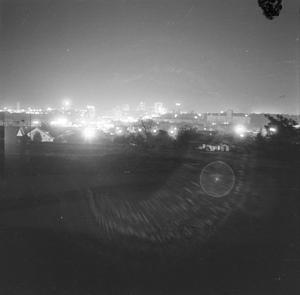 [Photograph of downtown Fort Worth at night from a distance]