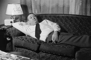 [Photograph of a man reclining on a couch]