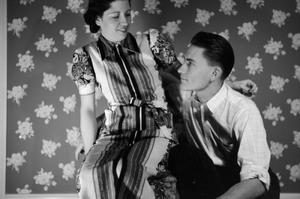 [Photograph of a couple posing in front of a floral-print background, 2]