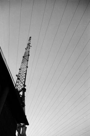 [Photograph of a radio tower behind a building]