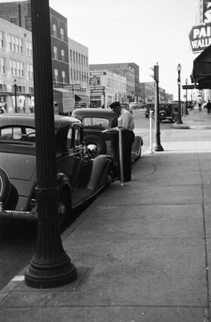 [Photograph of a police officer ticketing an automobile]