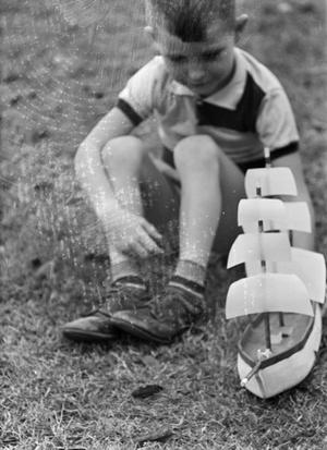 [Photograph of Tim Williams playing with a toy boat, 5]