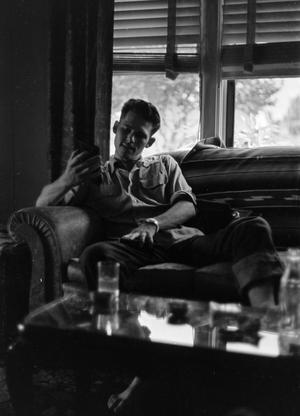 [Photograph of a man sitting on a couch]