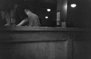 [Photograph of men behind a bar]