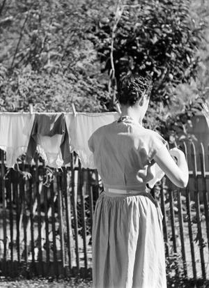 [Photograph of Doris hanging clothes on a clothesline]