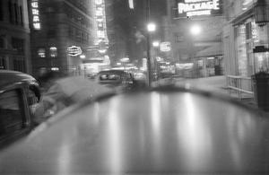 [Photograph of a street lit up with neon signs]