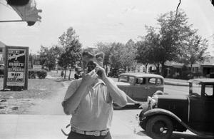 [Photograph of a man holding up a small camera]