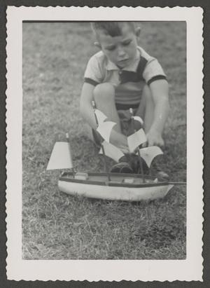 [Photograph of Tim Williams playing with a toy boat, 7]
