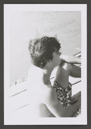 Primary view of object titled '[Photograph of a teenage boy sitting on a dock]'.