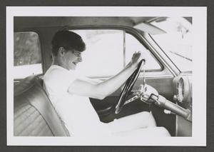 [Photograph of a teenage boy in the driver's seat of an automobile]