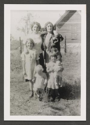 [Photograph of two women and three children posing outside]