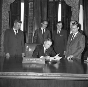 [Texas Governor Price Daniel signing paperwork with people behind him, 2]