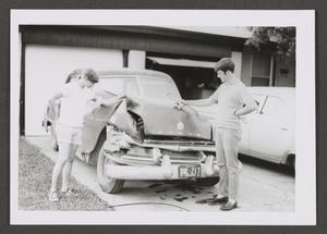 [Photograph of two teenage boys by a wrecked automobile]