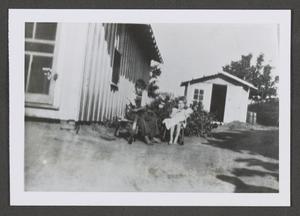 [Photograph of a young boy and girl sitting outside]