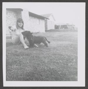 [Photograph of Pam Williams sitting in a backyard with Angus]