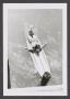 Photograph: [Photograph of a girl lying on a surfboard]