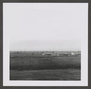 [Photograph of a flat landscape with houses]