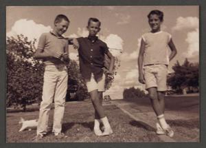 [Photograph of three boys posing in a yard]