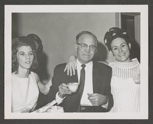 [Photograph of two men and a woman at a Christmas celebration]