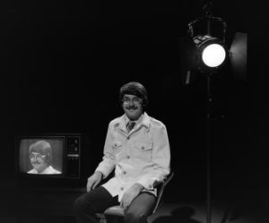 Primary view of object titled '[Photograph of David Finfrock posing for a portrait by a television, 6]'.
