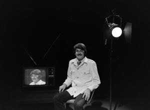 [Photograph of David Finfrock posing for a portrait by a television, 3]