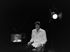 [Photograph of David Finfrock posing for a portrait by a television]