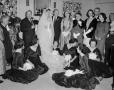 Photograph: [A bride and groom surrounded by guests]