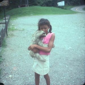 [Young girl holding a sloth]