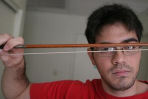 [Student looking through violin bow]