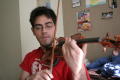 Photograph: [Student practicing on violin in dorm]
