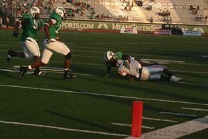 [UNT players running towards tackled FAU player, September 22, 2007]