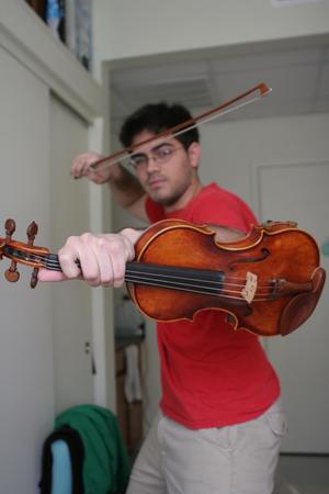 [Student posing with violin and bow]