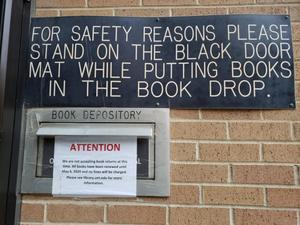 [COVID-19 signage at Willis Library book drop]