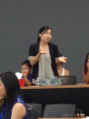 [Young woman speaking at CSA meeting]