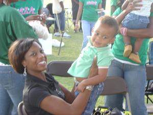 [Woman holding child at UNT tailgate]