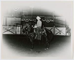 [Man on horseback holding prize ribbon]