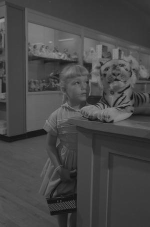 [Cheryl looking at a stuffed toy tiger]