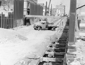 [Photograph of a construction site with a truck parked in the dirt]