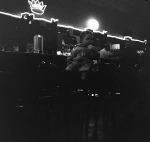 [Photograph of a little boy sitting at a counter]