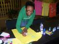 Photograph: [Woman decorating yellow shirt from Clothesline Project]