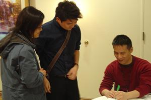 [B. D. Wong signing papers for guests]