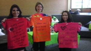 [Women holding shirts from Clothesline Project]