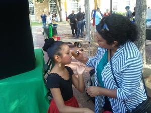 [Young girl getting her makeup done at carnaval]